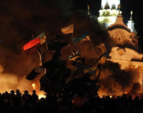 Anti-government protesters gather near a statue during clashes with riot police at Independence Square in Kiev